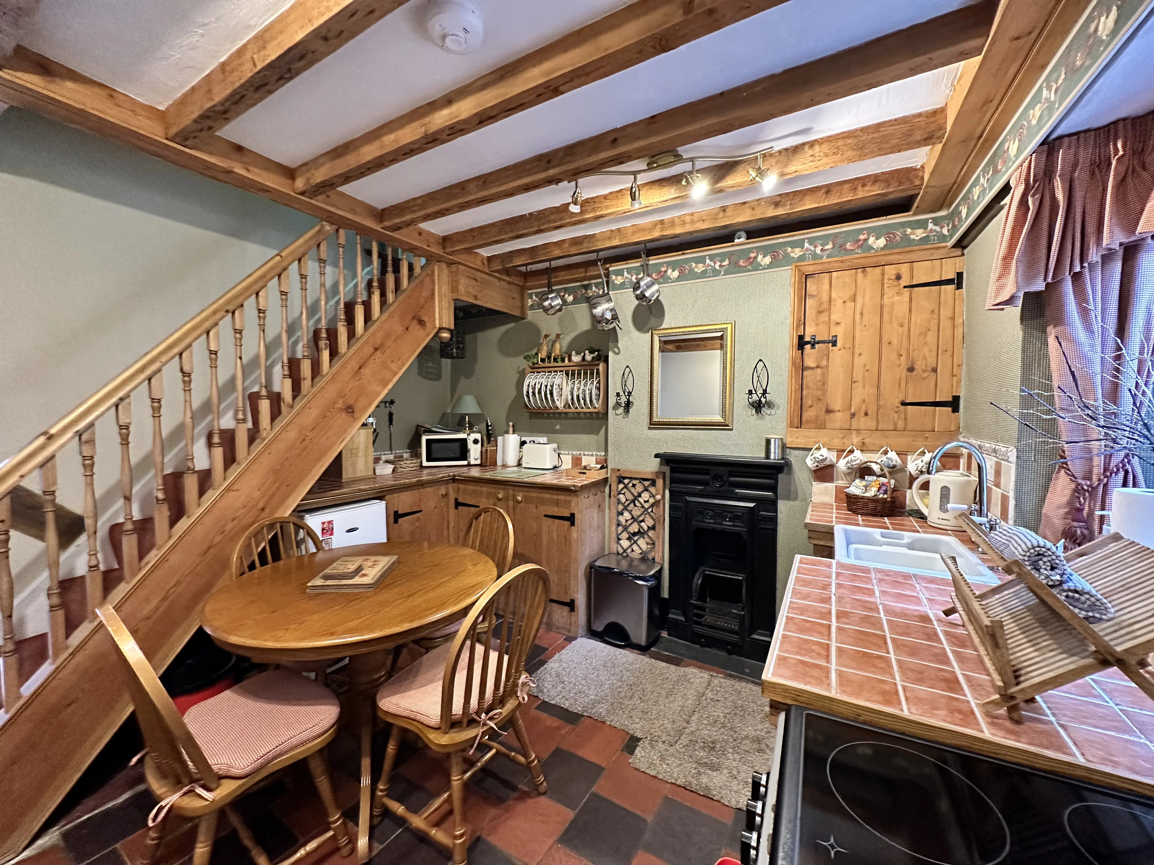 Kitchen with oak beams, dining table and cast iron range